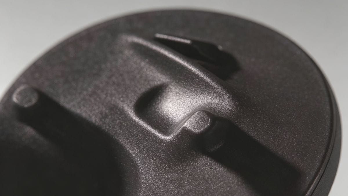 Close-up of a sink mark defect on a plastic injection molded part near a rib.