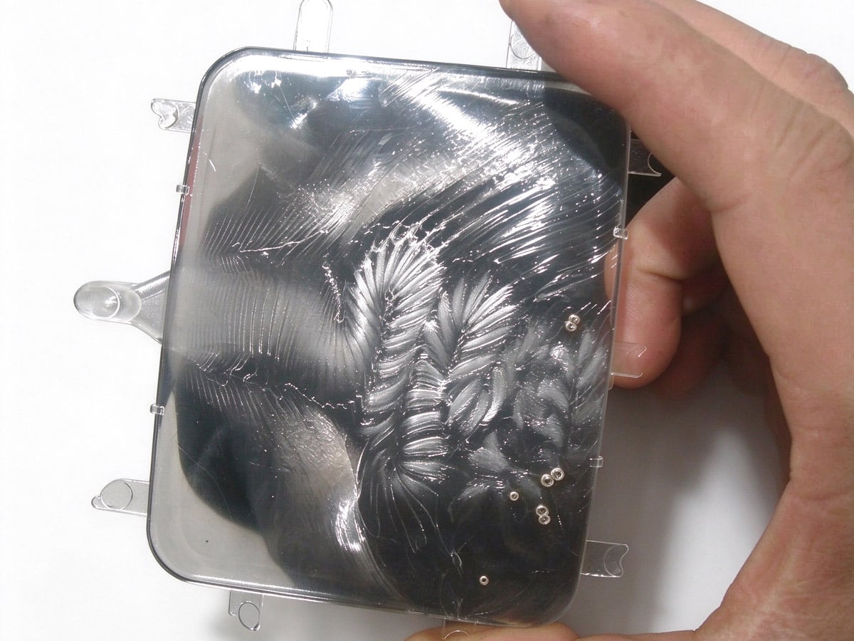 Cloudy, mottled surface defect near the gate on an injection-molded part